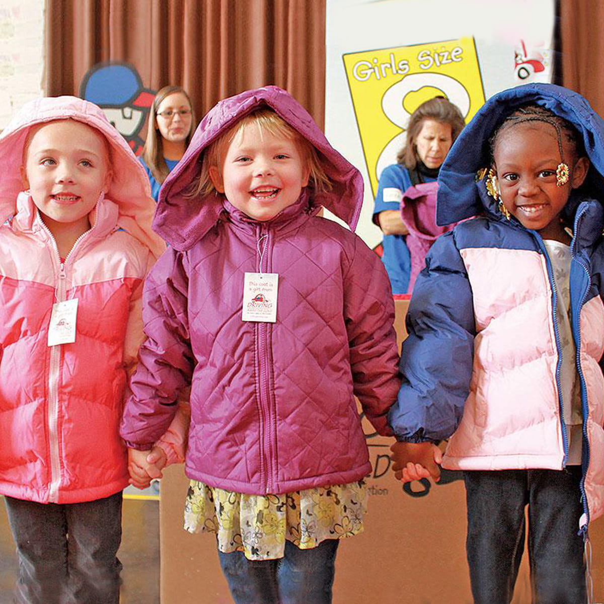Trois jeunes enfants portant des vêtements d'hiver et tenant la main