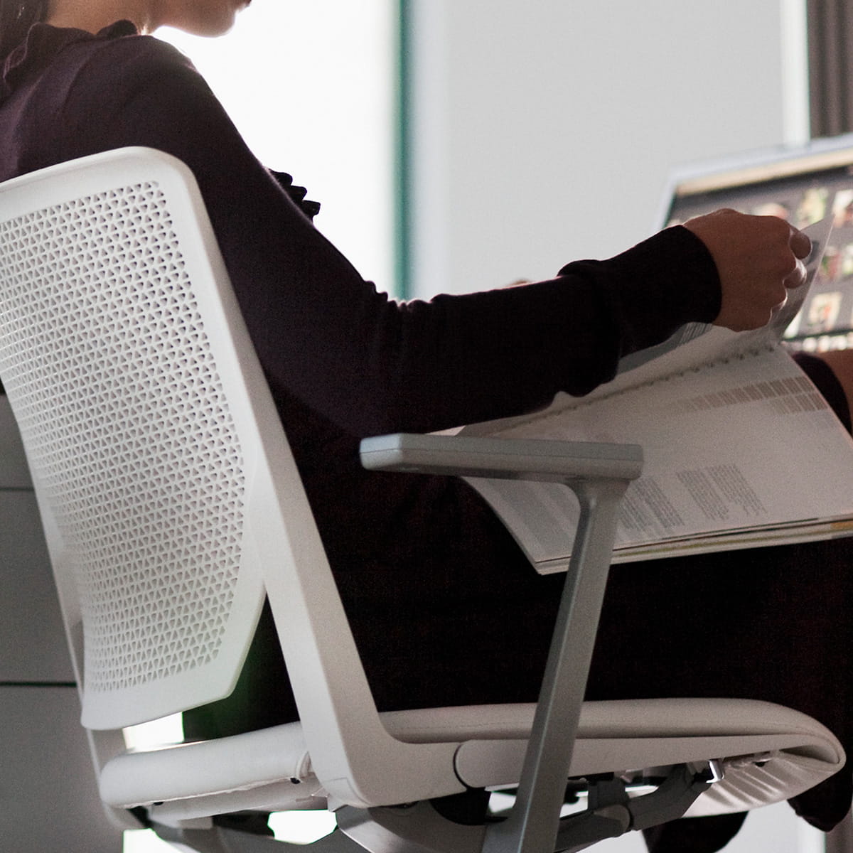 Office worker sitting at office desk looking at files