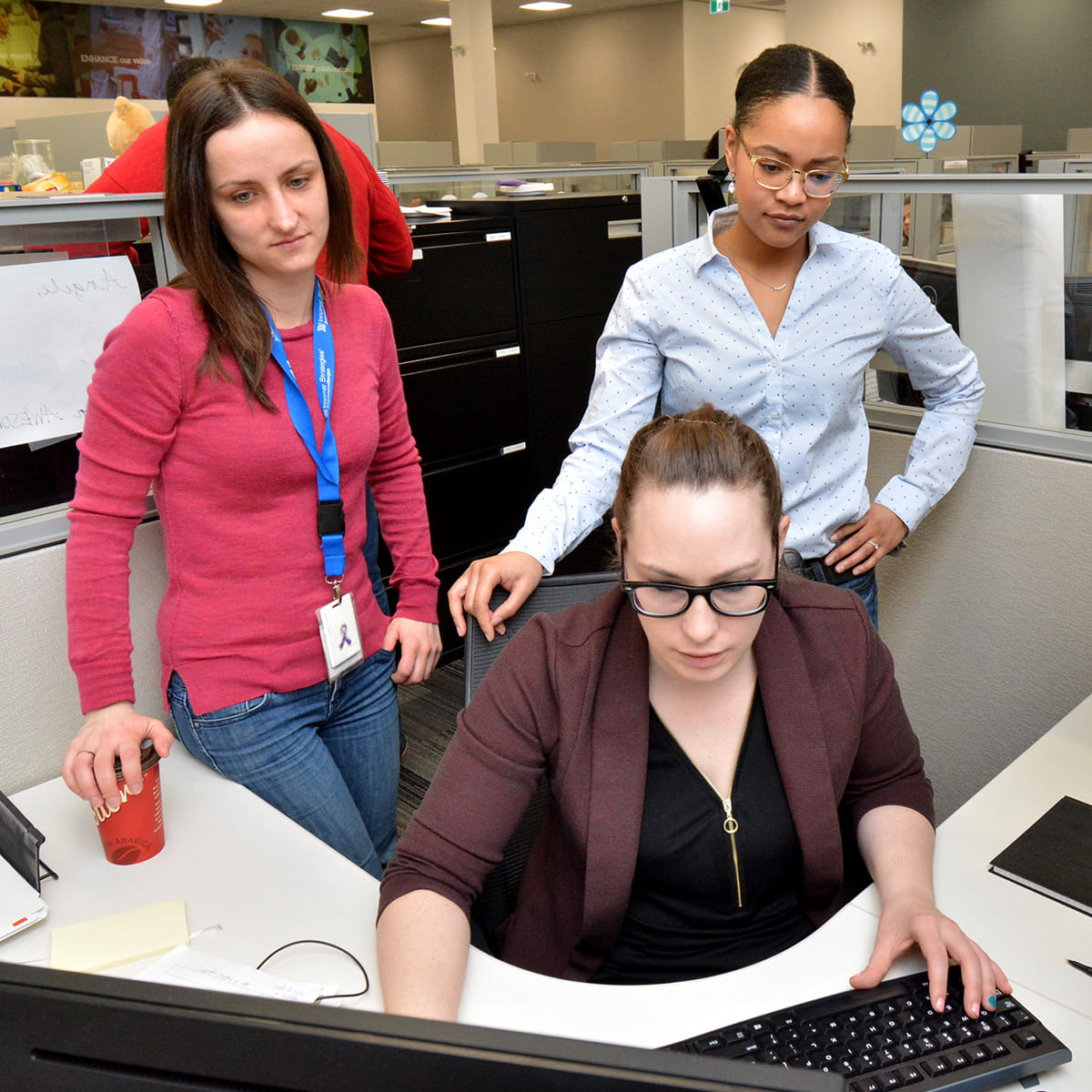 3 workers around a desk