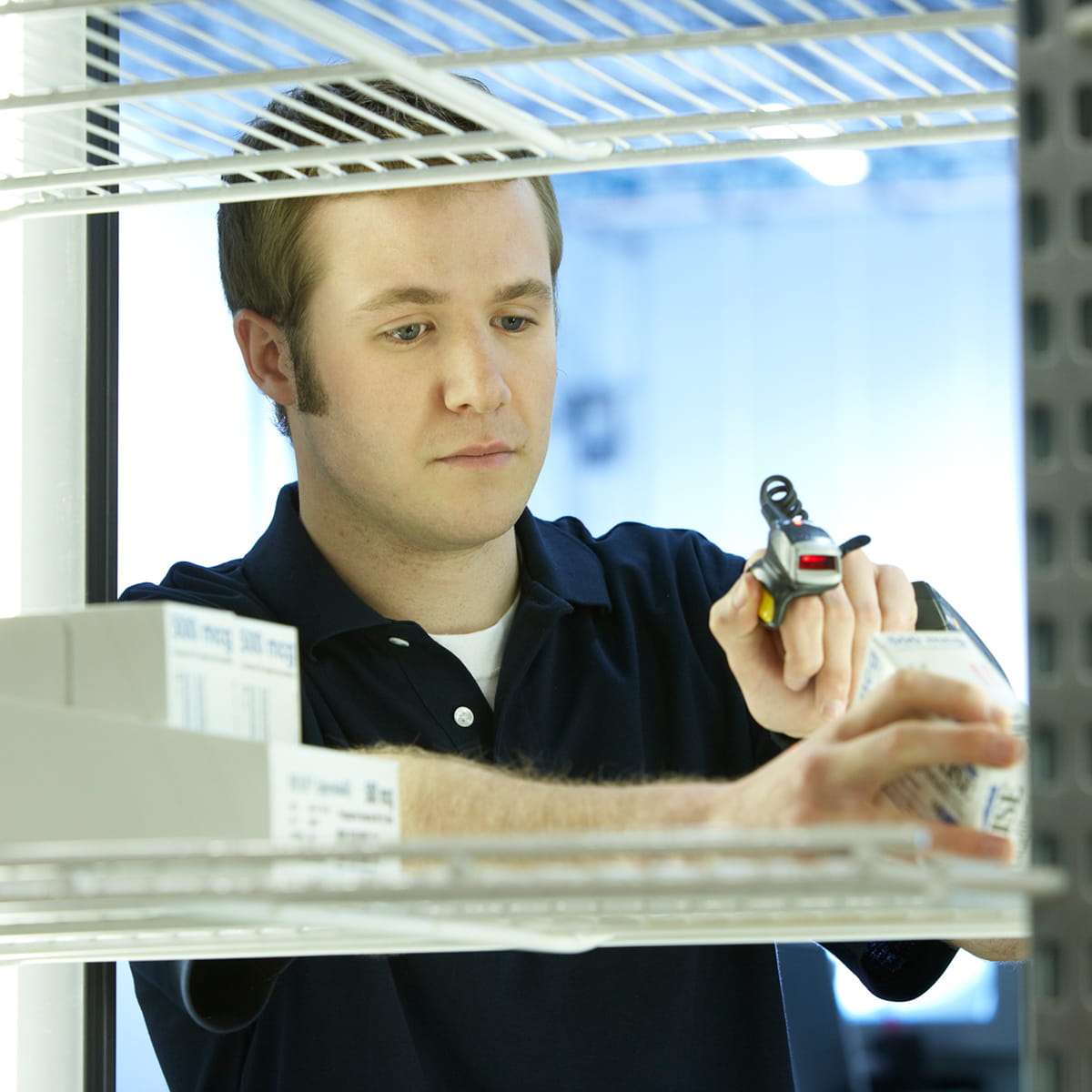Young man scanning refrigerated medicine