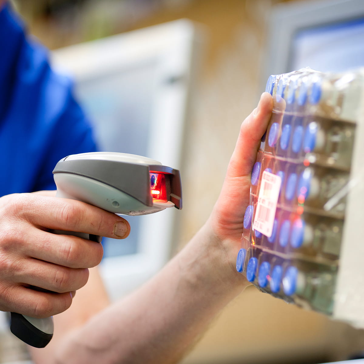 Employé scanne électroniquement un paquet de produit