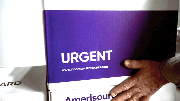  Une boîte portant une étiquette Urgent avec des doses de vaccin prêtes à être distribuées.