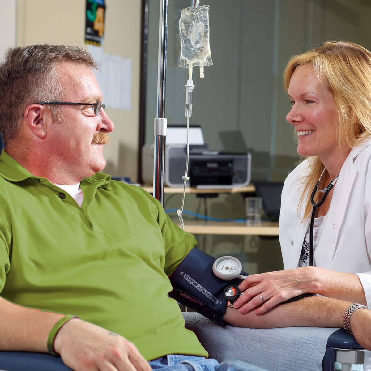 Nurse taking blood pressure of male patient